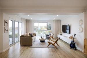 a living room with a couch and a chair at Luxurious Waterfront Retreat in Oatley in Oatley