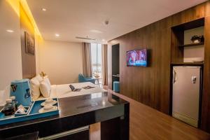 a hotel room with a counter and a refrigerator at Gold Central Hotel by Haviland in Da Nang