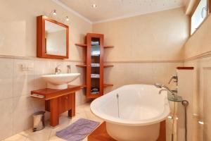 ein Badezimmer mit einer weißen Badewanne und einem Waschbecken in der Unterkunft Hotel Bergkranz in Mieders