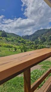 a wooden bench with a view of a mountain at Kōtare Cabin, Thames Coast in Tapu