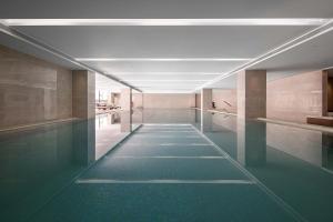 黄山市Huangshan Parkview International Hotel的建筑物内有绿色地板的长走廊