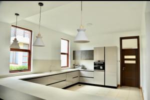 a kitchen with white cabinets and a refrigerator at Luxury Lakeside Villa Gated in Entebbe +13 photos