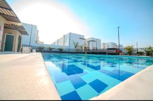 a large swimming pool with blue tiles on a building at Espectacular casa, piscina privada- Ricaurte in Ricaurte