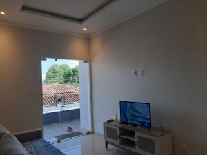 ein Wohnzimmer mit einem Sofa und einem TV auf dem Tisch in der Unterkunft Residencial Reis - Cozy and Comfortable Apto in Boa Vista