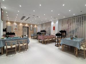 a dining room with tables and chairs and tablesearcher at 福禄寿酒店 in Beiwusidui