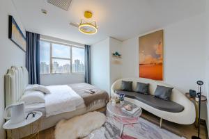 FushansuoQingdao Shanhaiji Sea View B&B Wusi Square Branch的带床和沙发的卧室