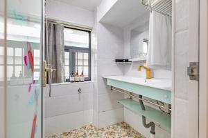 ein Badezimmer mit Dusche, Waschbecken und Spiegel in der Unterkunft Guangzhou City Center Apartment in Guangzhou