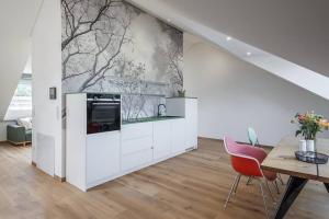 a kitchen with white cabinets and a wall with a mural at Wohnen in der Villa Kunterbunt nahe der 5-Seen-Landschaft in Puchheim