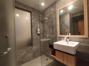 a bathroom with a sink and a glass shower at OPA Hotel Palembang in Sukarami +7 photos
