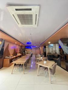 a restaurant with tables and chairs in a room at OPA Hotel Palembang in Sukarami