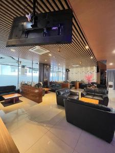 a large lobby with couches and tables in a building at OPA Hotel Palembang in Sukarami