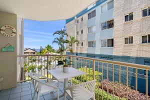 a balcony with a table and chairs and a pool at Cheltenham Unit 4 in Caloundra