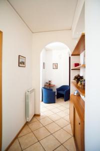 a hallway with a table and blue chairs in a room at Hotel La Toscana in Arezzo