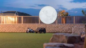 a large moon hanging over a brick wall with a toy car at Pause Kids Pool Viila in Yeosu