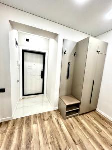 uno spogliatoio con pareti bianche e pavimenti in legno di Апартаменты в ЖК Атлант a Kökşetaw