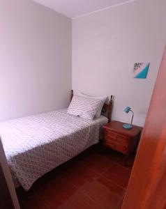 a small bedroom with a bed and a night stand at La Palmera in Lima