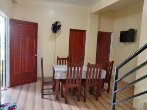 a dining room with a table and chairs and a television at Wyatt Transient House in Alaminos