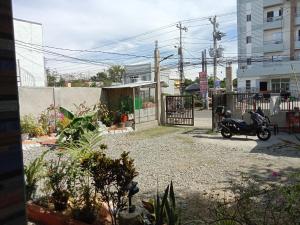 a scooter parked in a yard next to a building at Wyatt Transient House in Alaminos +3 photos
