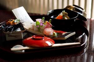ein Tablett mit zwei Schüsseln mit Essen auf einem Tisch in der Unterkunft TAKITEI Riverside Onsen ーA Hidden Ryokan in Kanazawaー in Kanazawa