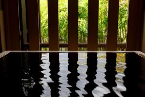 eine Wasserlache vor einem Fenster in der Unterkunft TAKITEI Riverside Onsen ーA Hidden Ryokan in Kanazawaー in Kanazawa + 112 Fotos