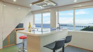 a kitchen with a bar with a view of the ocean at Samcheok Peacehousing Spa Pet Pension in Samcheok