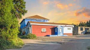 a group of buildings with a sunset in the background at Jeju CountryFarmpension in Seogwipo +7 photos