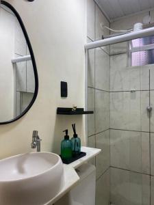 une salle de bain blanche avec un lavabo et une douche dans l'établissement Loft Ymará Arraial, à Arraial do Cabo