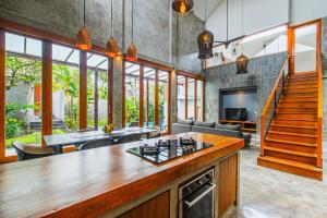 a kitchen and living room with a couch and a table at SooBali Niscala Villa 5 Bedroom in Canggu
