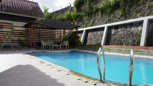 a swimming pool with a gazebo next to a house at Villa Dalia Puncak R4-19 in Cikundul