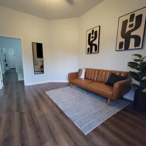 a living room with a couch and a rug at Trisuites in New Orleans