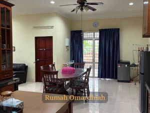 a kitchen and living room with a table and chairs at Rumah Omardhiah in Kuala Terengganu