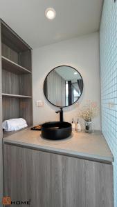a bathroom counter with a mirror and a sink at DSD Resort in Kon Rung (1)