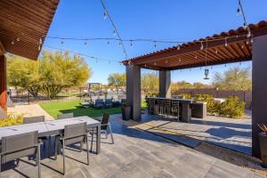 a patio with tables and chairs under a pergola at Lone Mountain Casita home in Cave Creek