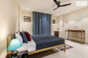ein Schlafzimmer mit einem Bett und einem Deckenventilator in der Unterkunft StayVista at Sundale Apartment with Heater & WiFi in Varanasi