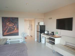 a living room with a couch and a kitchen with a refrigerator at Vip Condo Rayong beach in Rayong