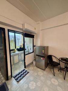 a small kitchen with a table and a refrigerator at Kimchi Apartment in Patong Beach