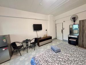 a bedroom with a bed and a desk and a television at Kimchi Apartment in Patong Beach