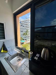 a kitchen sink with a view of a large window at Kimchi Apartment in Patong Beach +12 photos