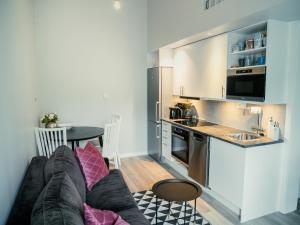 a living room with a couch and a kitchen at Fireside Lodge near Golf, Ski & Lake in Ågesta