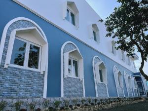 a blue and white building with arched windows at Hiệp Phát in Buôn Kô Tam