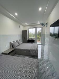 a bedroom with a bed and a desk in it at Hiệp Phát in Buôn Kô Tam +16 photos