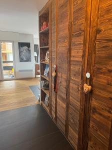 a wooden cabinet in a living room with aventory at Clair Vue A2 Telecabine by Jolidi in Nendaz