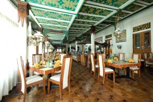 a dining room with wooden tables and chairs at Kusuma Sahid Prince Hotel Solo in Solo