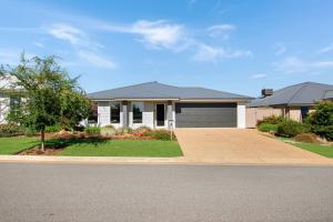 una casa con una entrada para autos en frente de ella en Thane Retreat - Cosy Ambience, Modern Entertaining, en Wagga Wagga