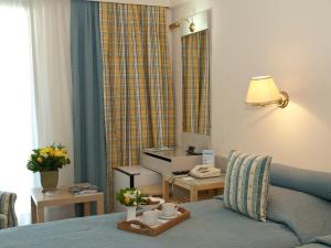 a hotel room with a bed and a table with cups on it at The Park Hotel Piraeus in Piraeus