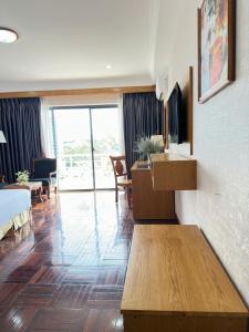 a living room with a bed and a table at Khách Sạn Mường Thanh Grand Gia Lai in Pleiku