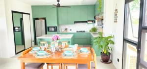 a kitchen with a wooden table and green cabinets at Casa Mel Mar Luxurious 3BR 3FullBR Villa with Pool in Panglao