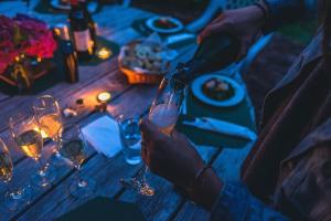 乌代浦Hotel Shivani Udaipur的一个人把酒杯放在桌子上