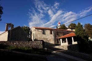 an old stone building with a church in the background at Apartments Beni in Matulji