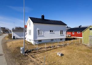 ein weißes Haus, das auf einem Hof steht in der Unterkunft Vikanhuset in Andenes